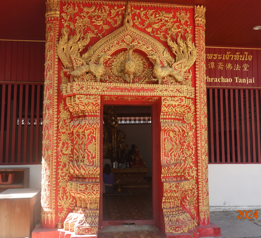 Red and gold decorated entrance to small hall at Wat Buppharam Chiang Mai, Thailand