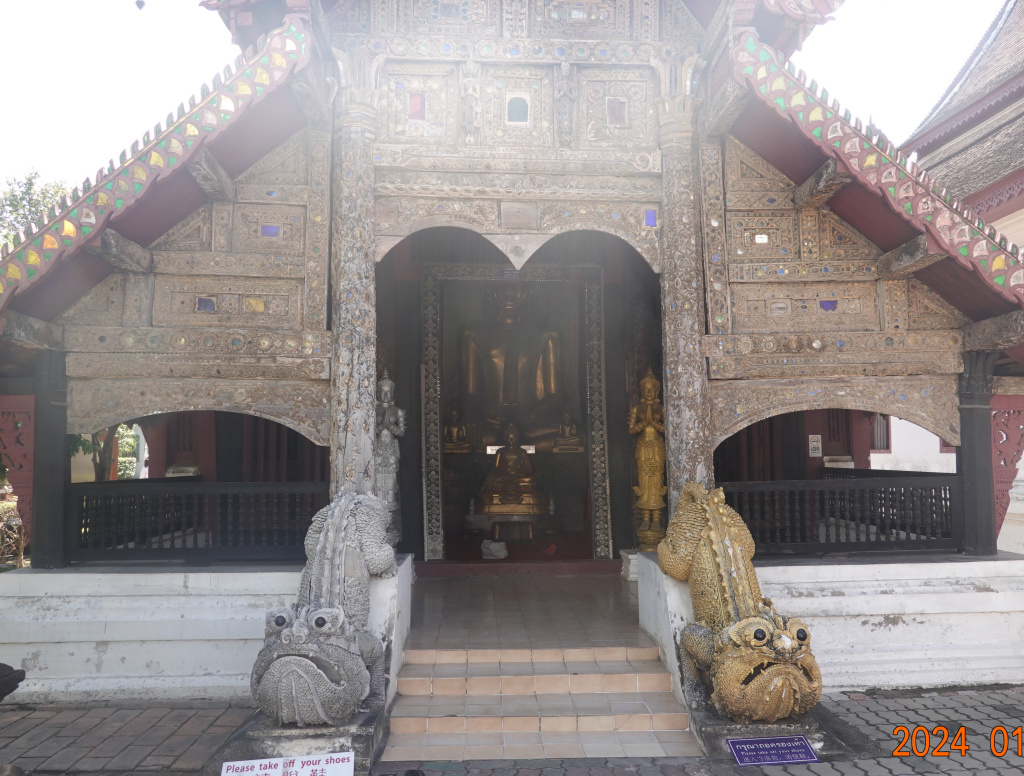 Wooden hall guarded by lizard-like creatures at Wat Buppharam, Chiang Mai, Thailand