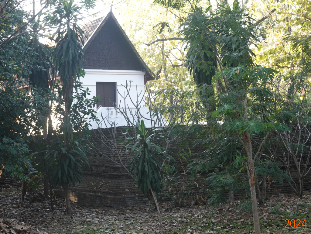 View of ubosot through the trees, Wat Jed Yod, Chiang Mai, Thailand