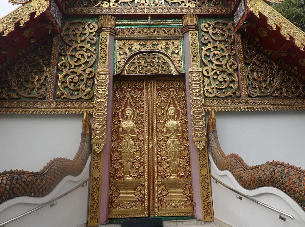 Ornate gold and red viharn doors at Wat Fon Soi, Chiang Mai, Thailand